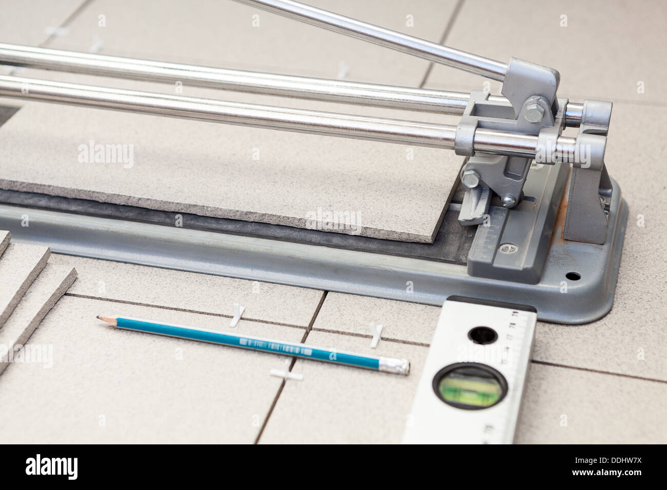 Small tilecutter with laying tiles, pencil and level tube Stock Photo