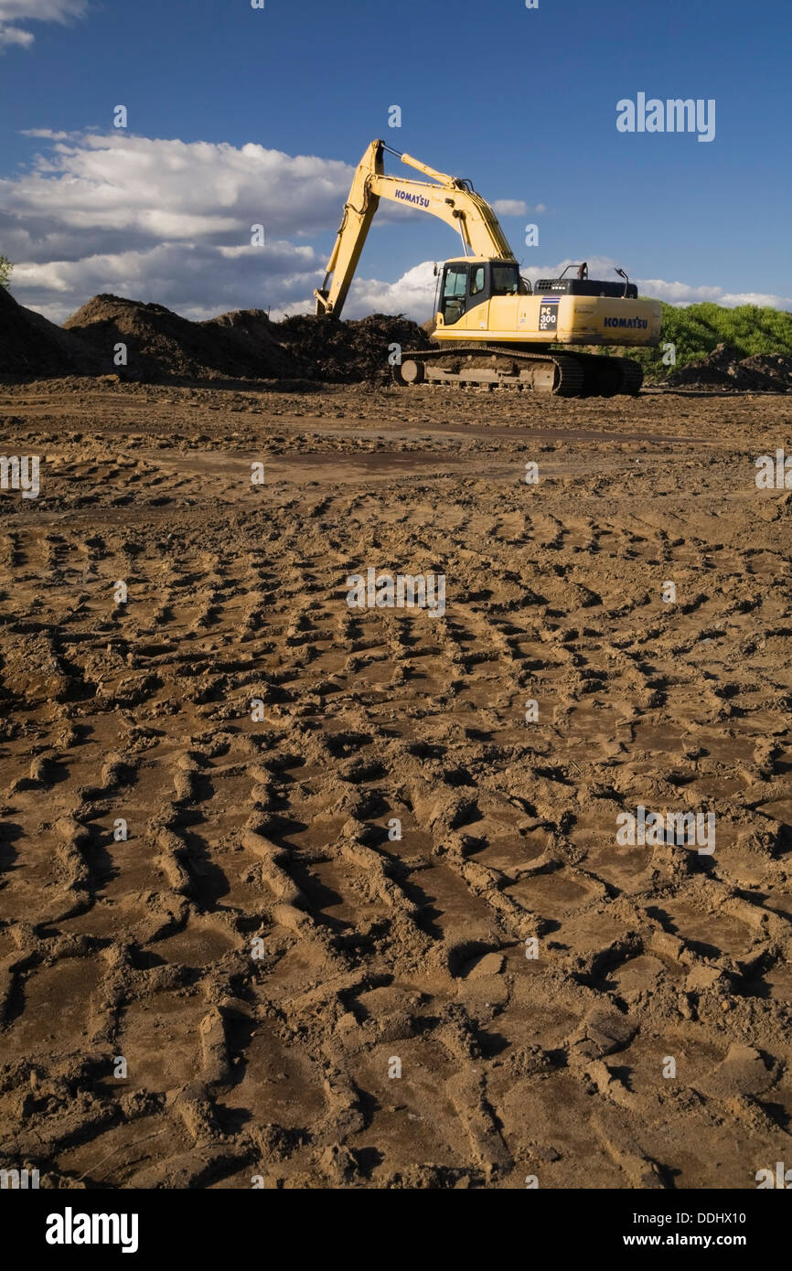 Heavy tire tracks and excavator in a commercial sandpit Stock Photo