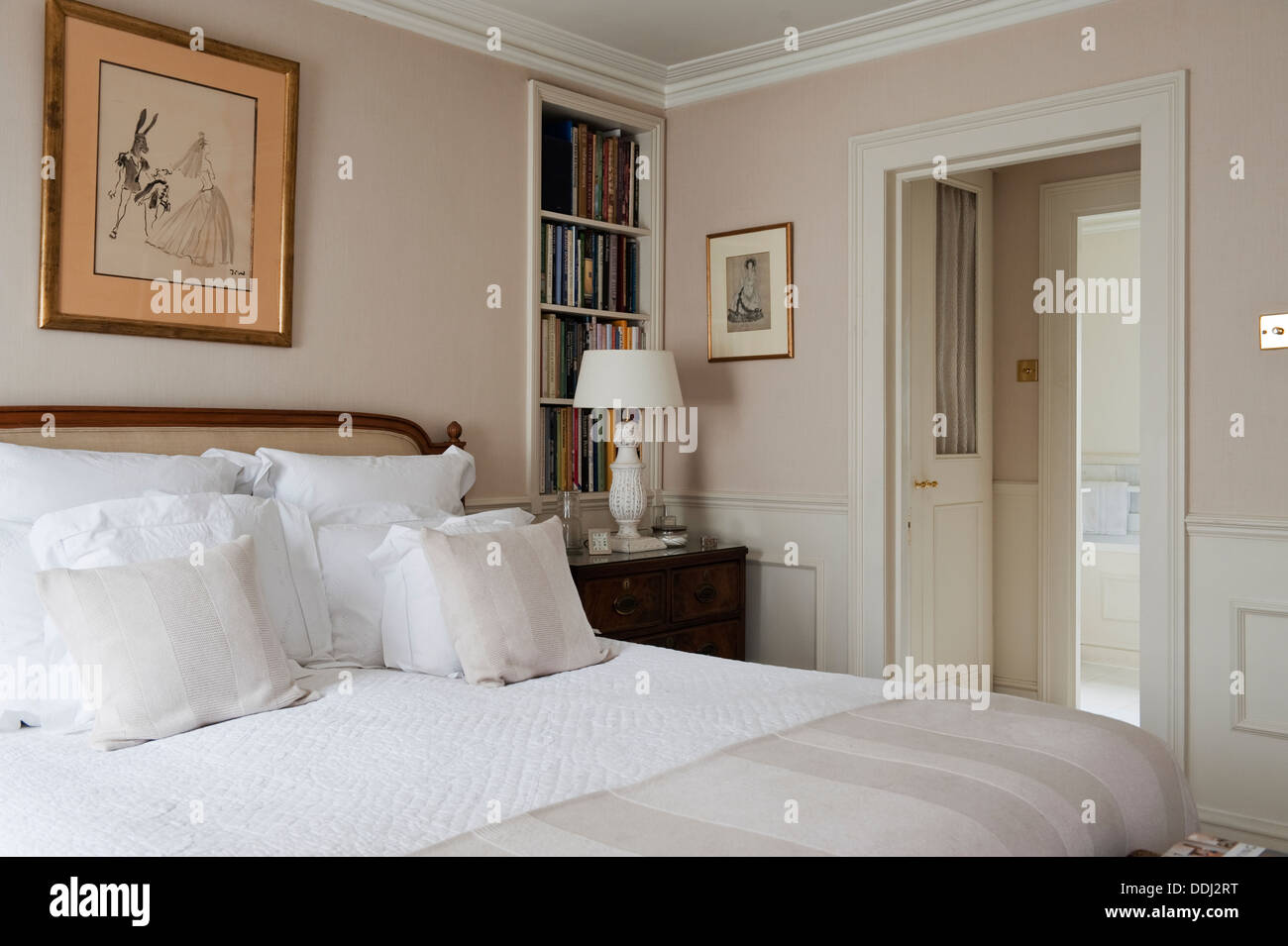 White company pillows on a bed with a padded inset headboard in Nina Campbell fabric. Stock Photo