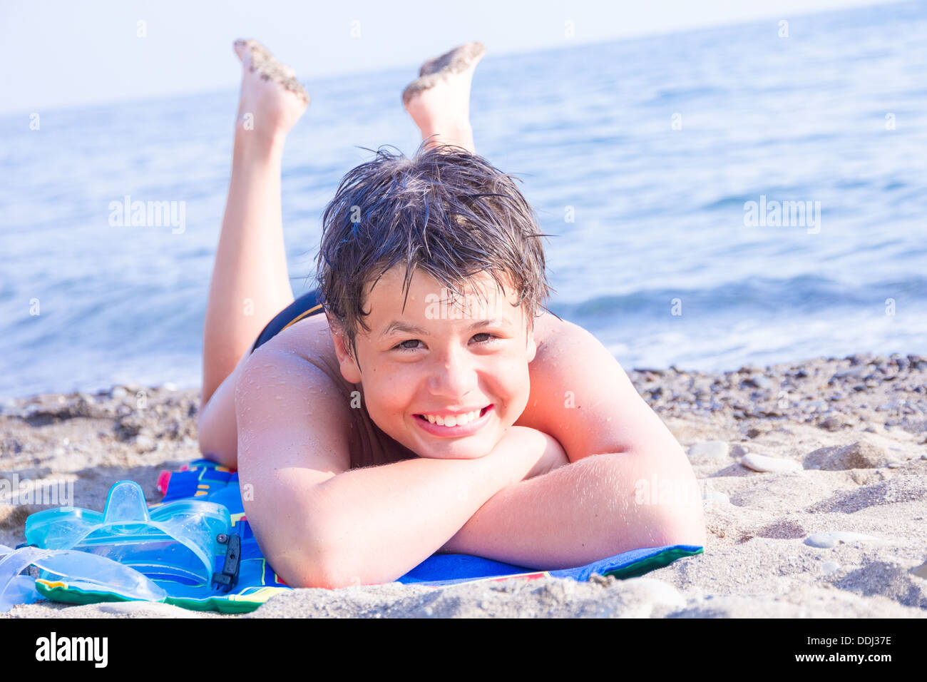 happy laughing boy of twelve with a scuba mask on the sea beach Stock Photo
