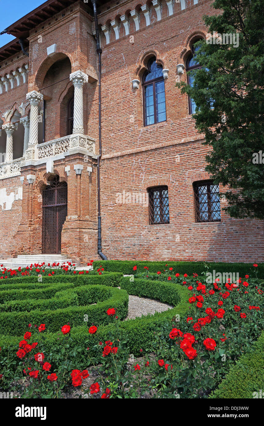 The back facade of the Mogosaia Palace in Romania and its red roses ...