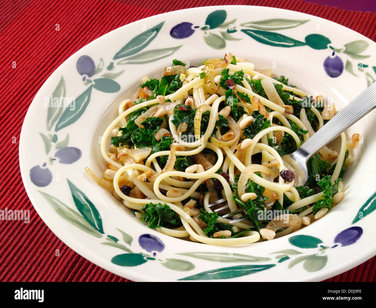 Vegetarian linguine pasta fried onions kale pine nuts hires stock