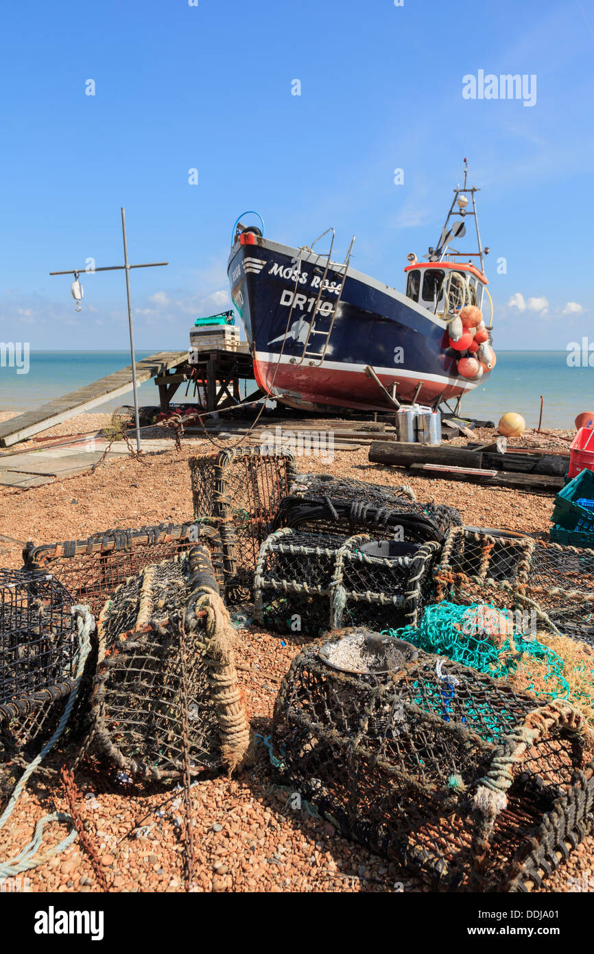 Fishing boat and lobster pots on the south coast shingle beach in Deal, Kent, England, UK, Britain Stock Photo