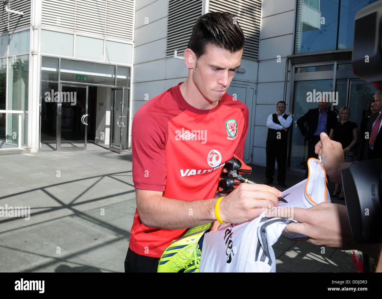 Cardiff, Wales, UK. 3rd September 2013. Real Madrid signing Gareth Bale signing a football shirt while leaving the St Davids Hotel in Cardiff today to head off for training with the Wales Football squad. Credit:  Phil Rees/Alamy Live News Stock Photo