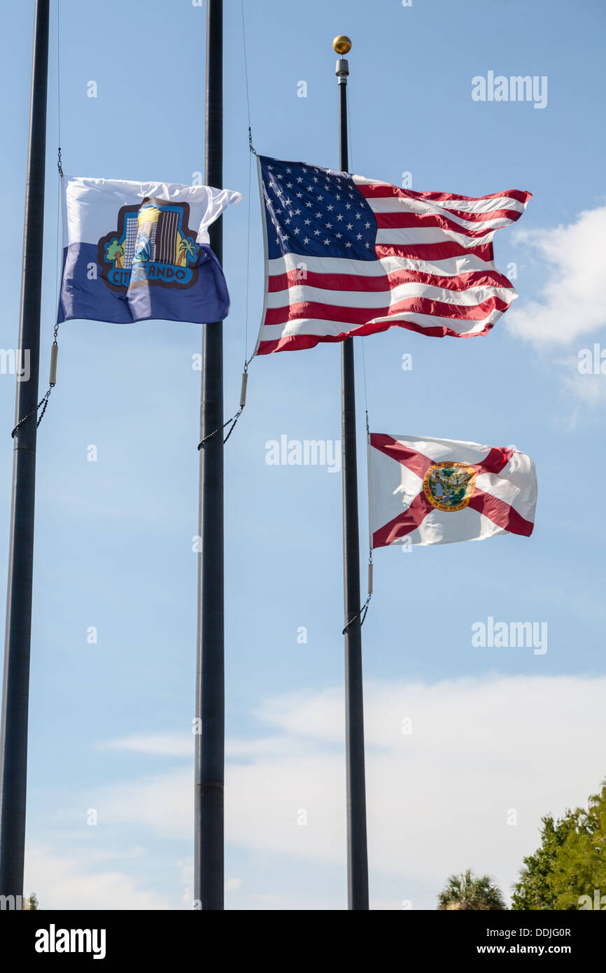 US, City of Orlando and Florida state flags flying at half mast at Lake Eola in downtown Orlando, Florida Stock Photo
