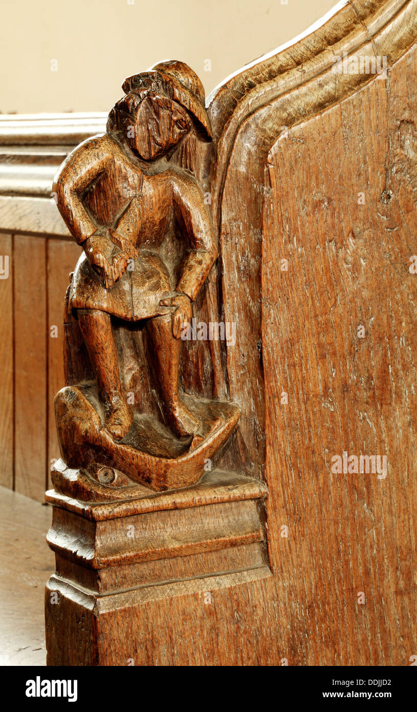 Medieval bench end, Anger, Seven Deadly Sins, angry man with knife in Jaws of Hell, carved wood art English bench ends Thornham Stock Photo