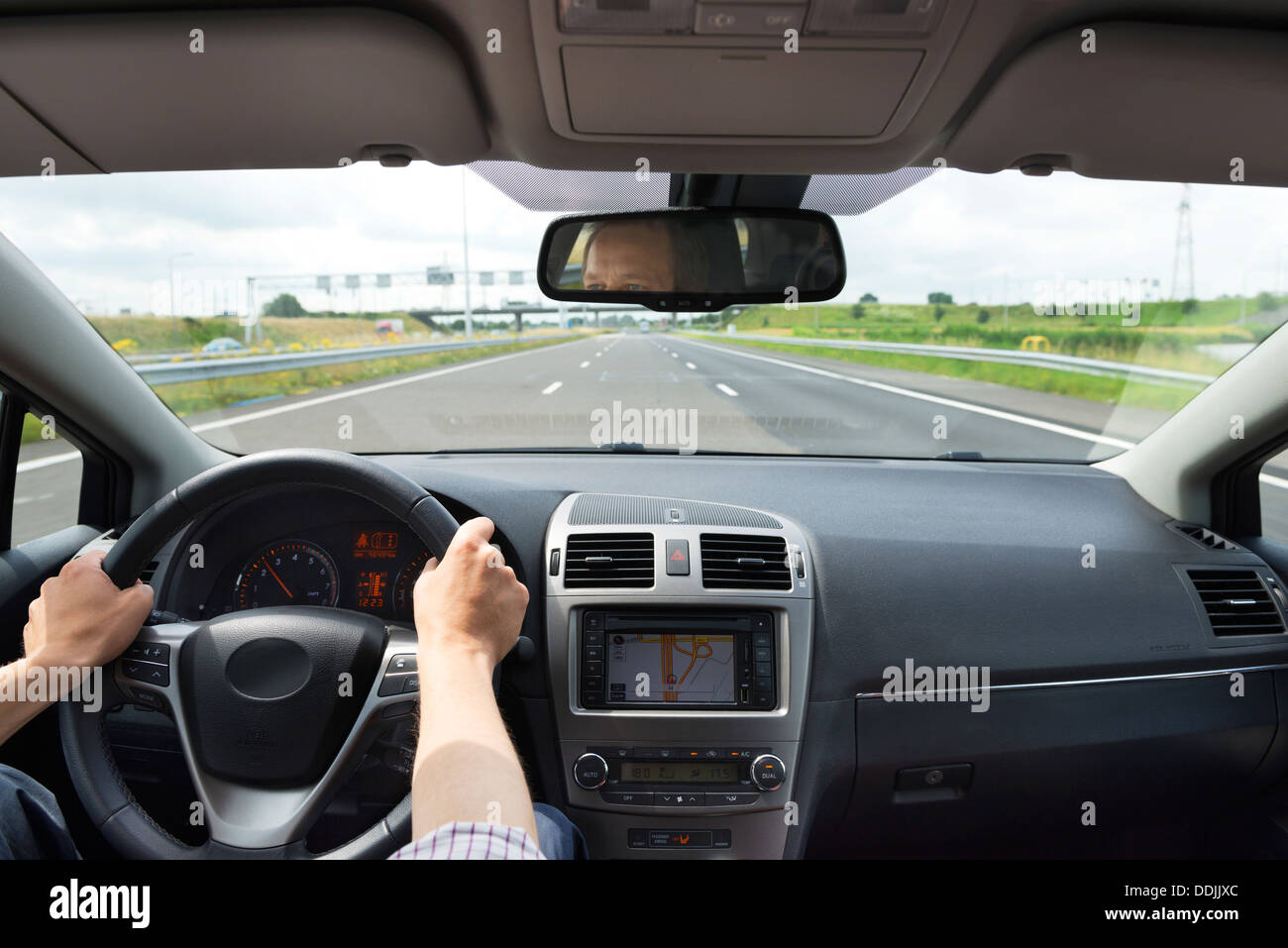 Mobility concept of a driver inside a modern, luxurious car on a motorway in the center lane Stock Photo
