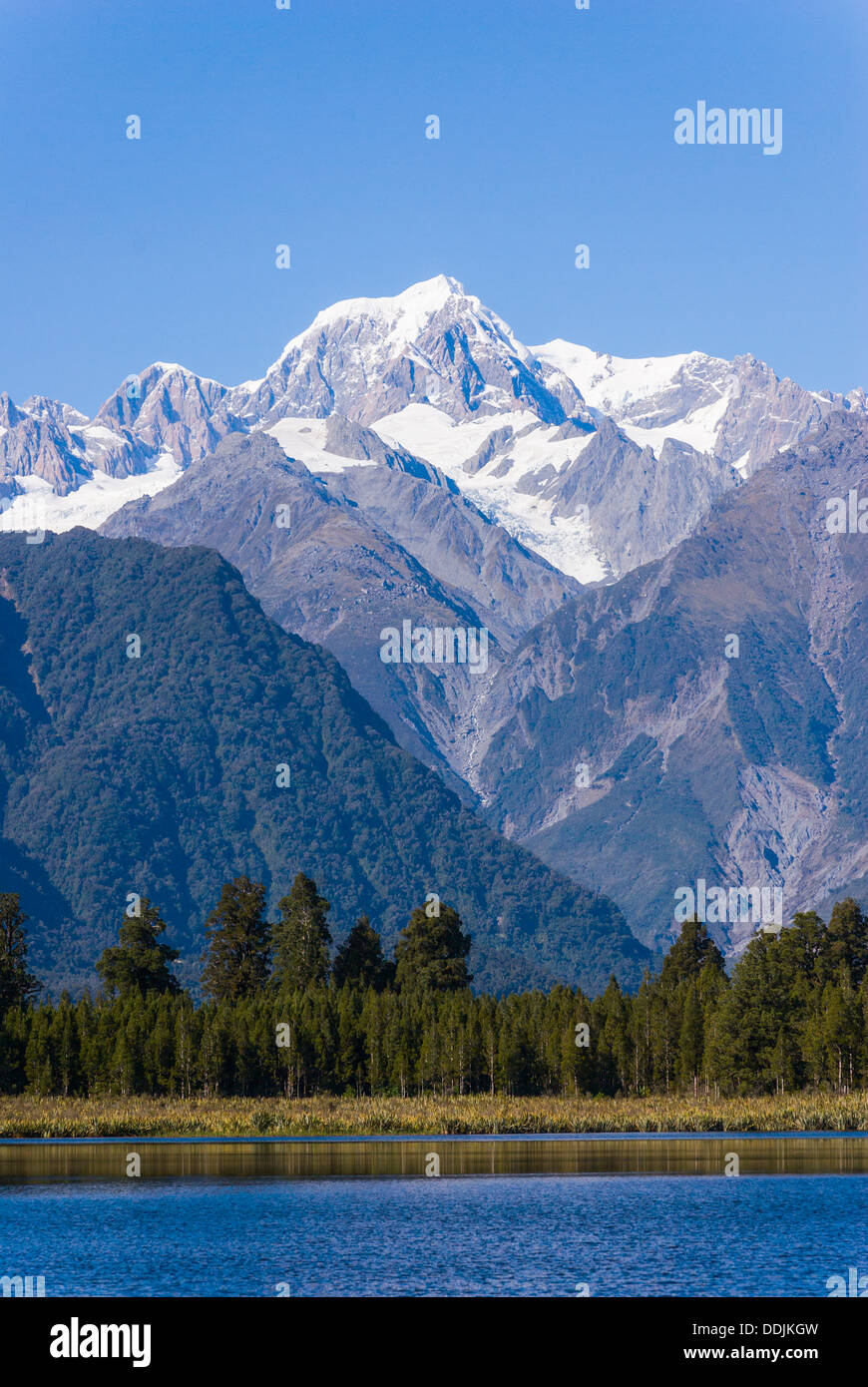 Mount Tasman (3497m) is the second highest mountain in New Zealand and is seen here from Lake Matheson, near Fox Glacier. Stock Photo