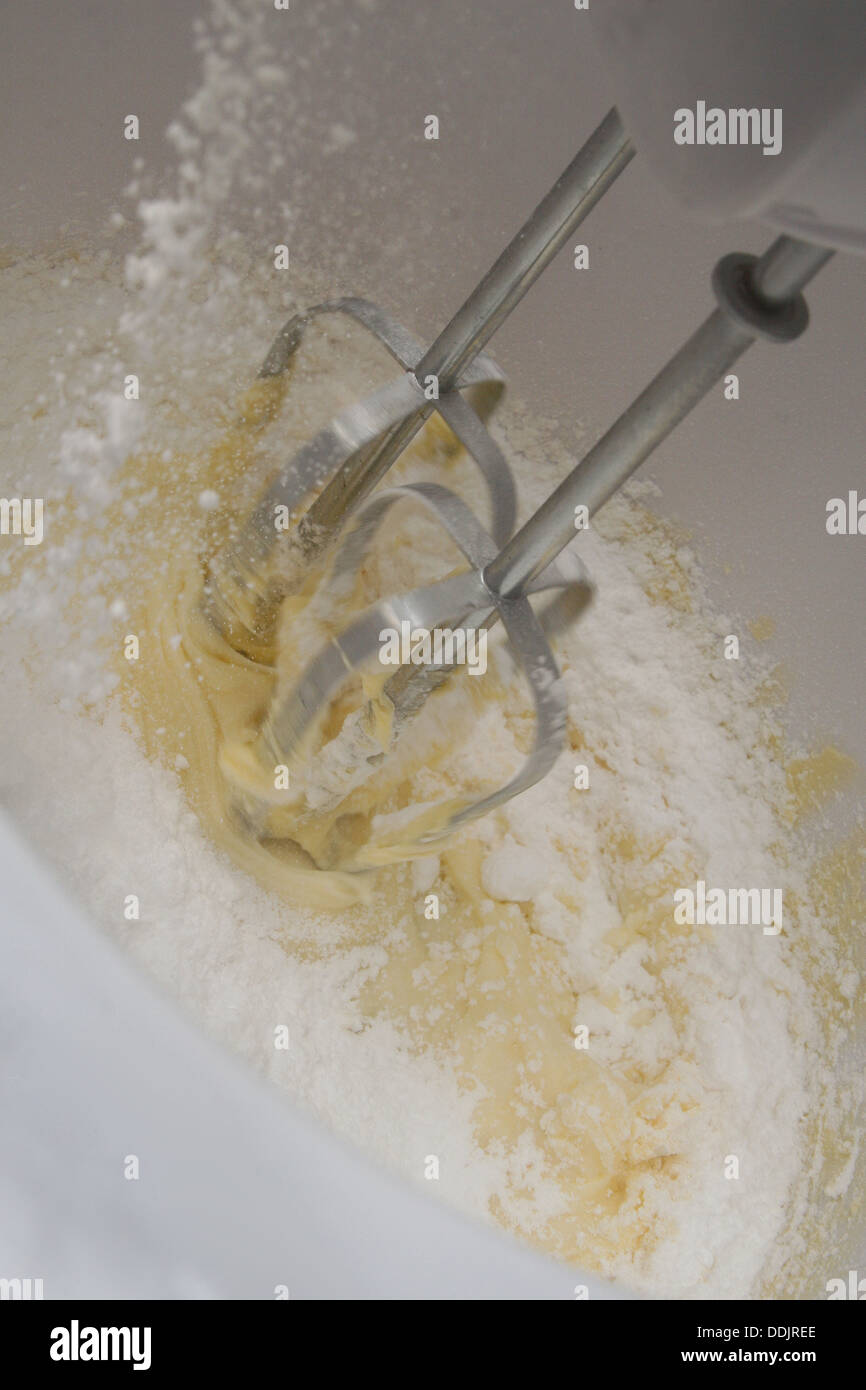 icing sugar pouring into white mixing bowl to make buttercream Stock