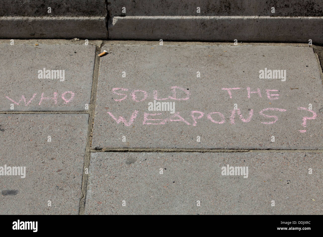 Words written in Pink Chalk on the Pavement outside Parliament London Protest for Syria 'who Sold them the weapons' Stock Photo