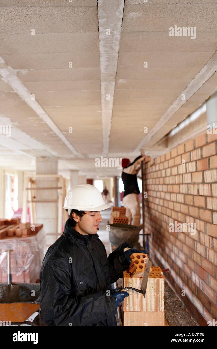 Bricklayer, bricking up a partition wall, new homes under construction, construction site Stock Photo