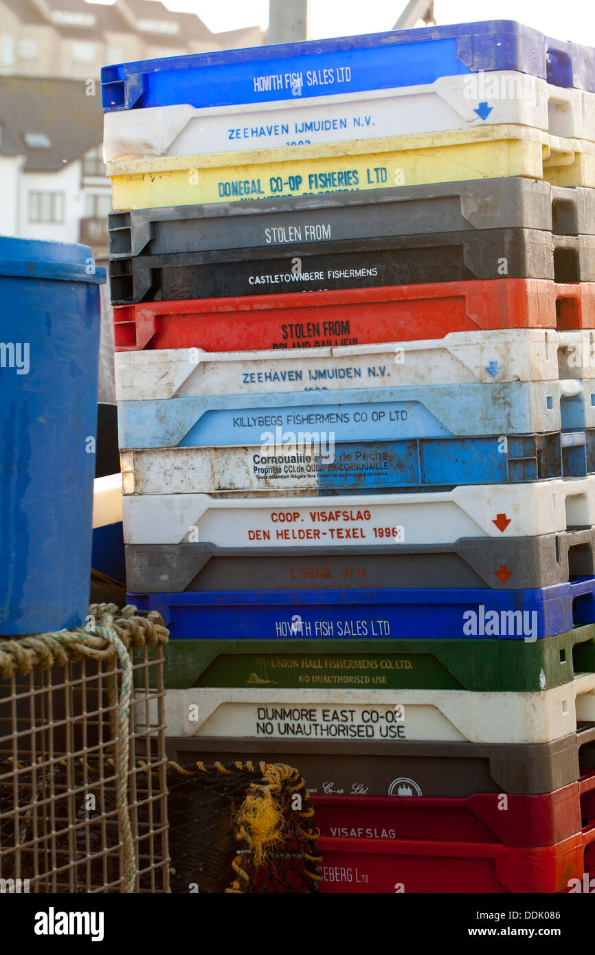 Stack of plastic fish boxes on a quayside. Aberystwyth, Ceredigion, Wales. January. Stock Photo