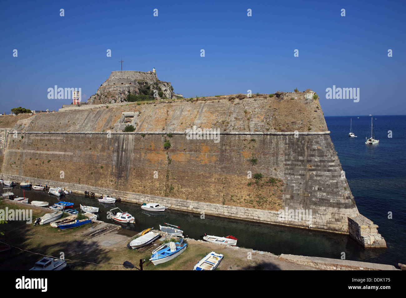 The high and steep defense walls of the Old Fortress in Corfu Town in Greece which is built on a rocky peninsula. Stock Photo
