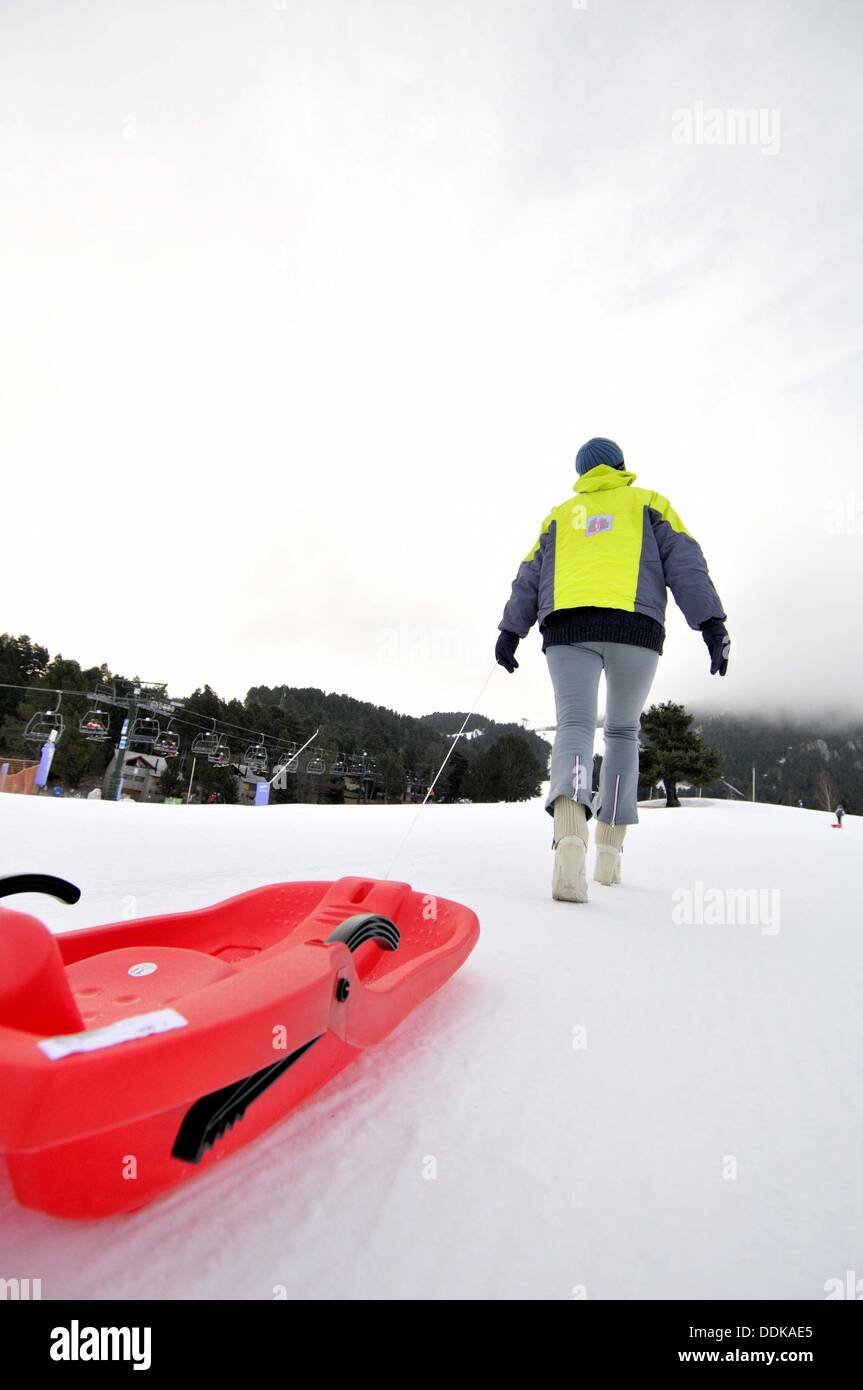 Boy dragging a plastic sled. La Molina ski resort, Cerdanya, Girona