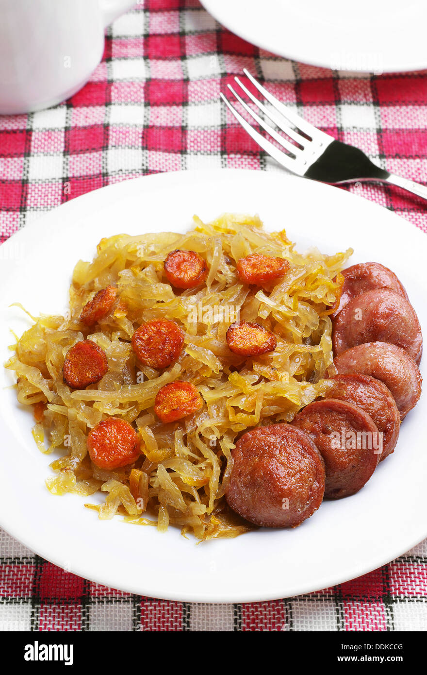 Braised cabbage with grilled sausage on a table Stock Photo