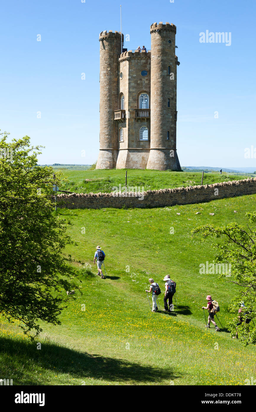 Hikers on the Cotswold Way National Trail approaching Broadway Tower on Broadway Hill, Worcestershire UK Stock Photo