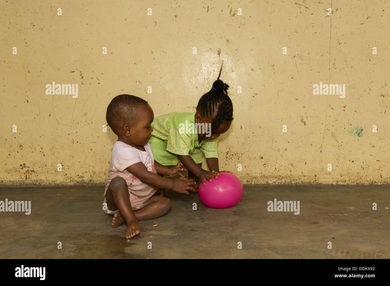 Toddlers seating on a concrete floor in Nigeria Stock Photo