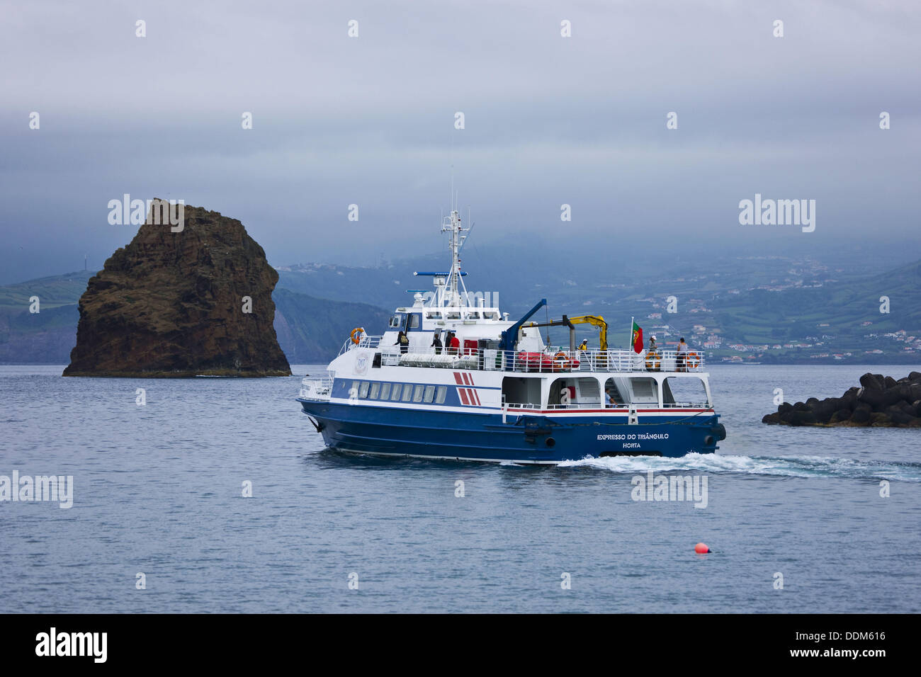 Boat, rocks and Madalena in background, Pico Island, Azores, Portugal Stock Photo
