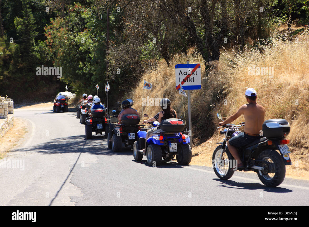 Quad Safari going through the Greek town of Lafki on the slopes of Mount Pantokrator in Corfu Stock Photo