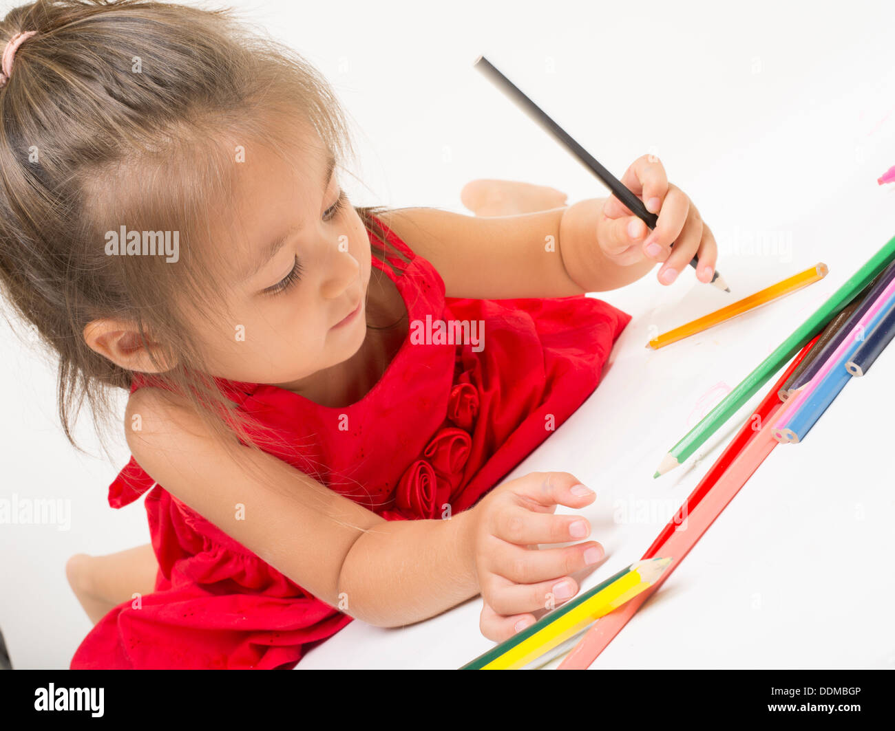 Young girl coloring with colored pencils Stock Photo