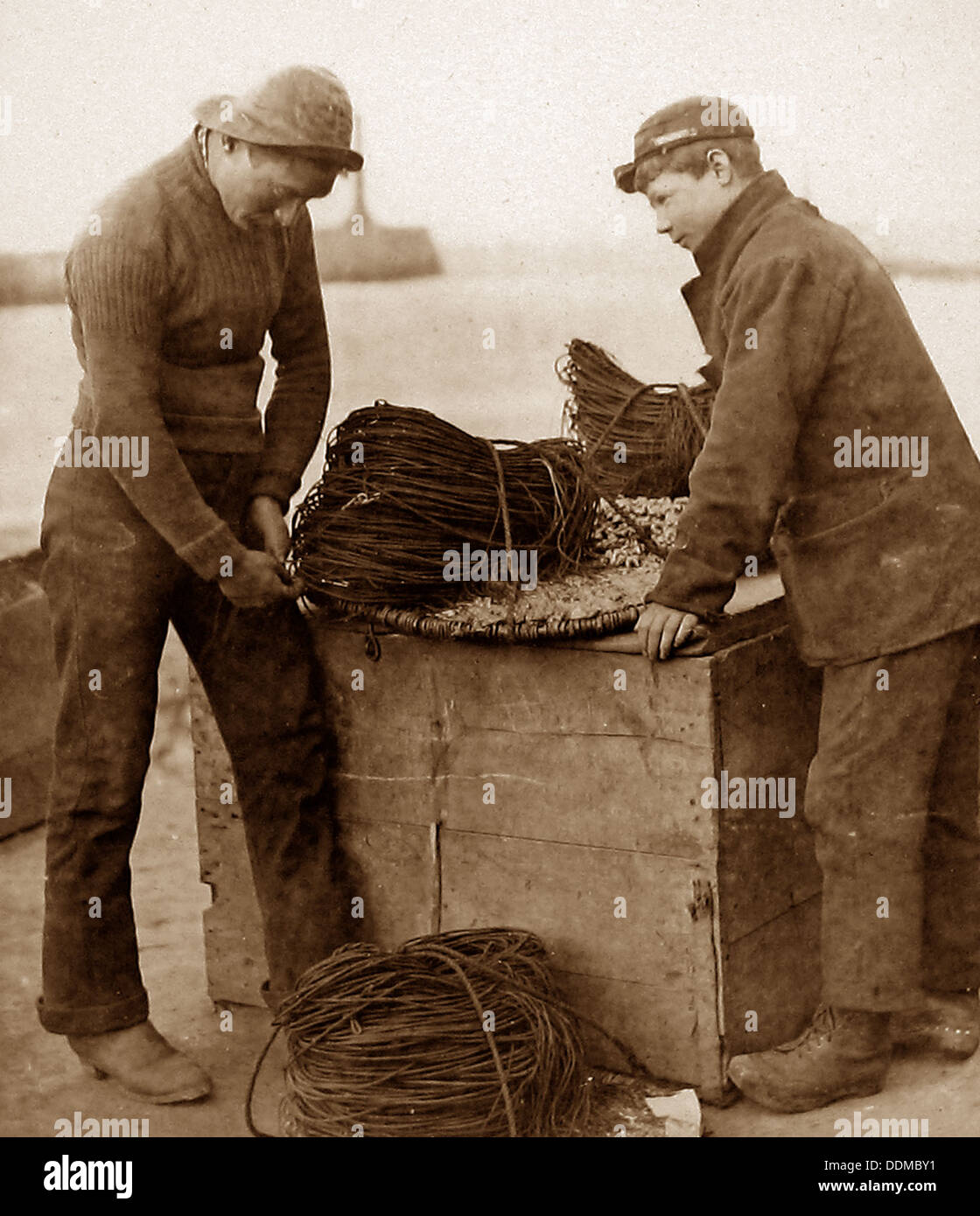 Fisherman baiting lines early 1900s Stock Photo