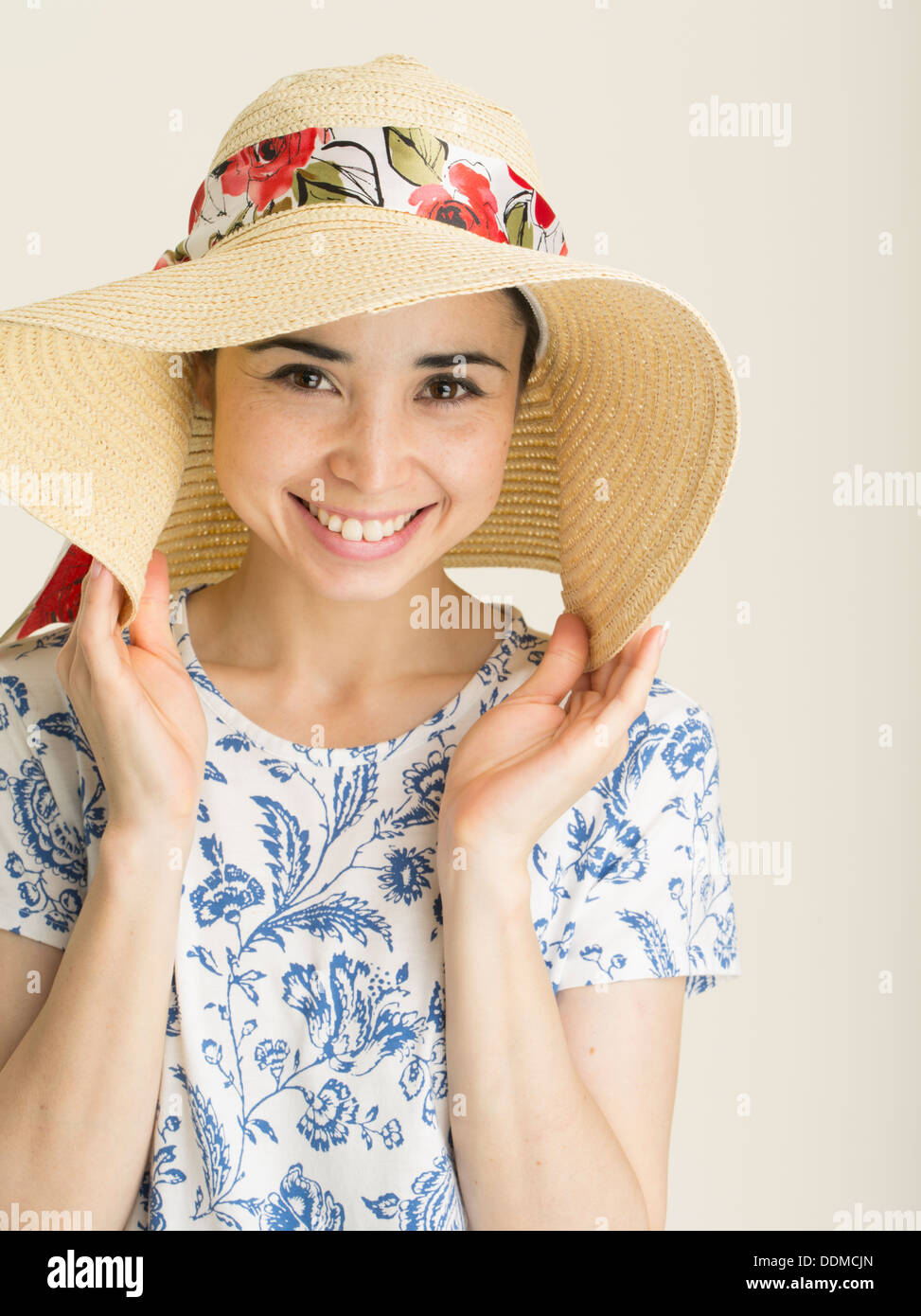 Young woman with pale skin staying out the sun with wide brimmed sun hat. Prevention of sun burn / skin melanoma Stock Photo