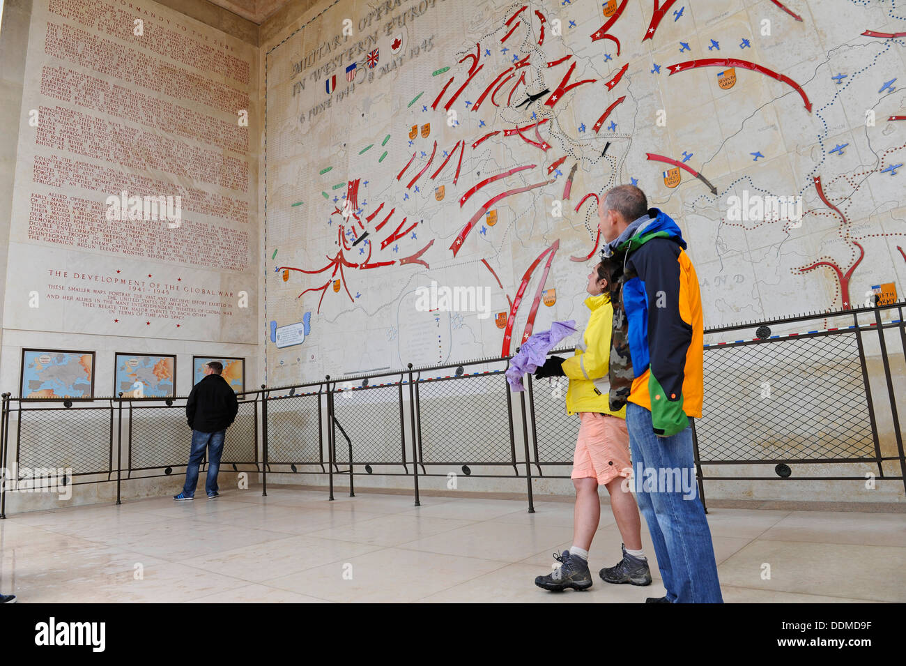 Visitors at the Omaha beach American war cemetery looking up at the large map showing the progression of the Normandy landings. Stock Photo