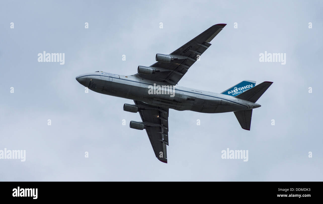 Antonov 124-100 UR-82073 jumbo jet cargo transporter plane flying underbelly landing lights on flaps down cloudy sky Stock Photo