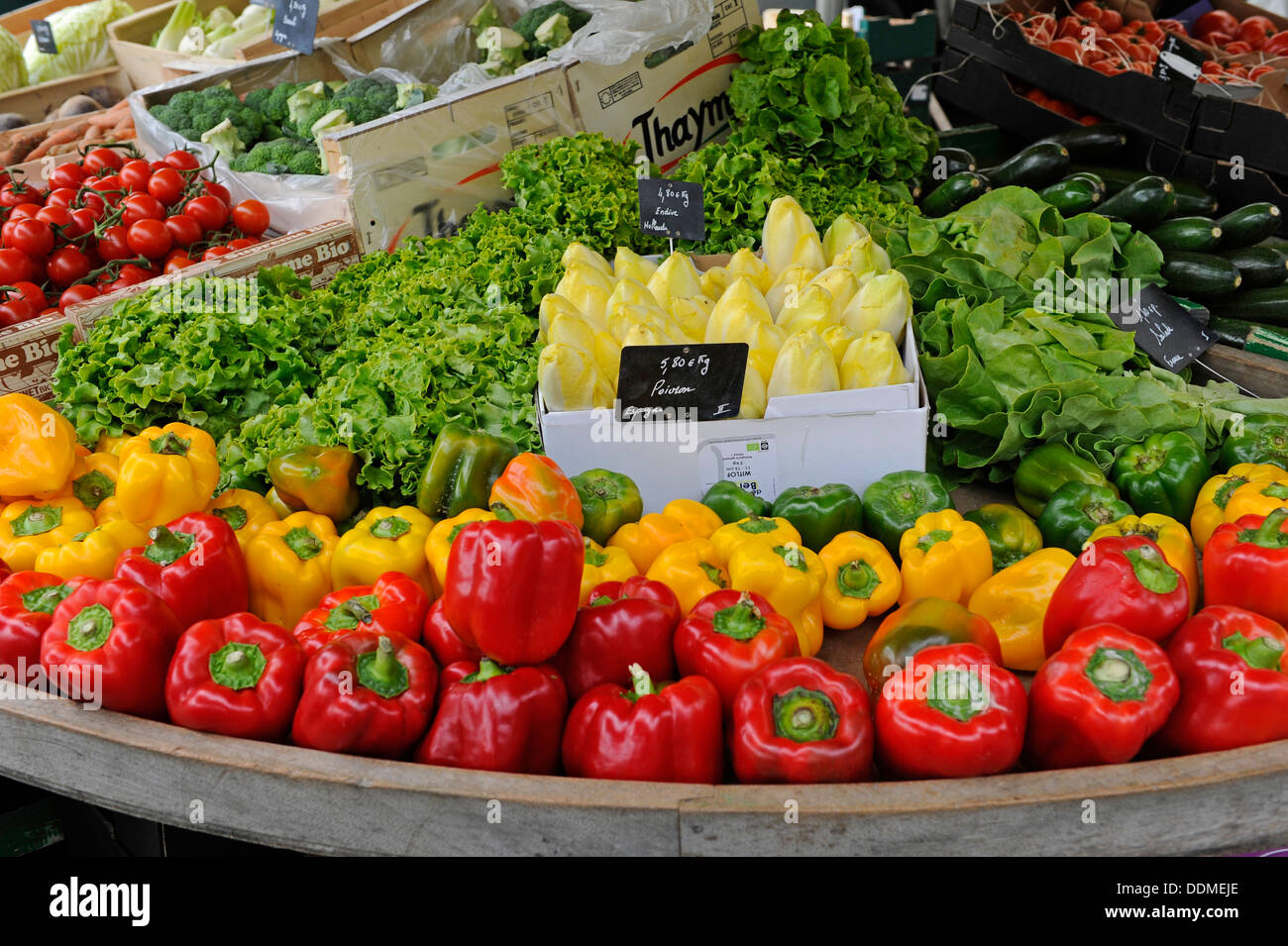 Red and yellow peppers and other vegetables for sale at a open market ...