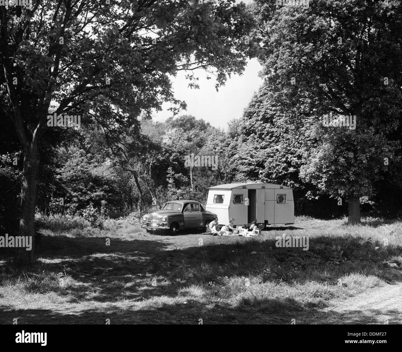 A family relaxing on holiday with their 1951 Vauxhall Wyvern and caravan, (1951?). Artist: Unknown Stock Photo