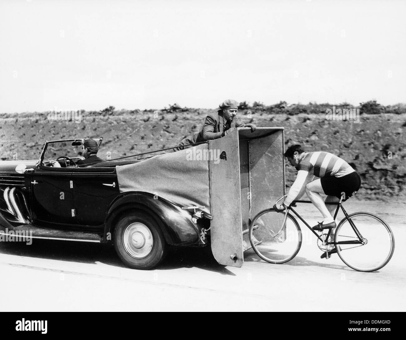 Cyclist training behind an Auburn car, c1935. Artist: Unknown Stock Photo