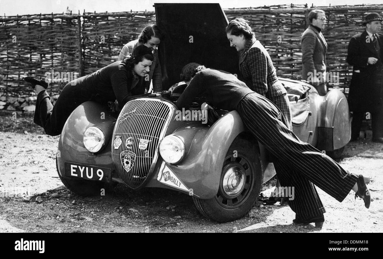 Miss MD Patten looking at the engine of a 1938 Peugeot 402 Special Sport, RAC Rally, 1939. Artist: Unknown Stock Photo