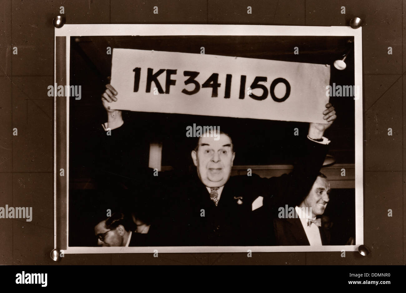 Lord Mackintosh holds up the first winning premium bond number, 1966. Artist: Unknown Stock Photo