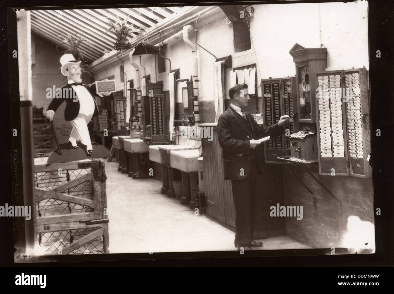 A man uses the clocking in machine, Rowntree factory, Yorkshire, 1929. Artist: Unknown Stock Photo