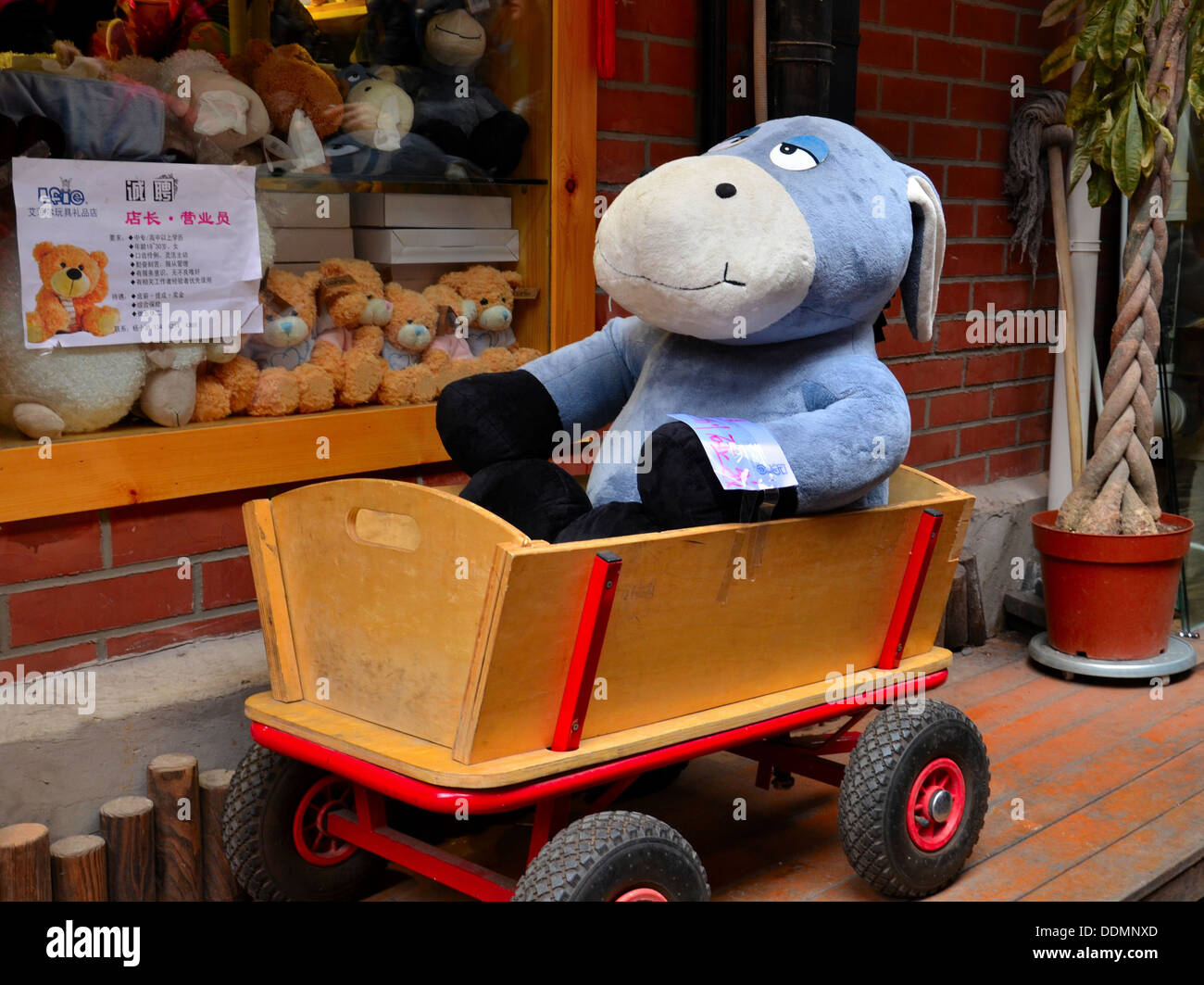 Stuffed donkey toy in wooden barrow cart Stock Photo Alamy