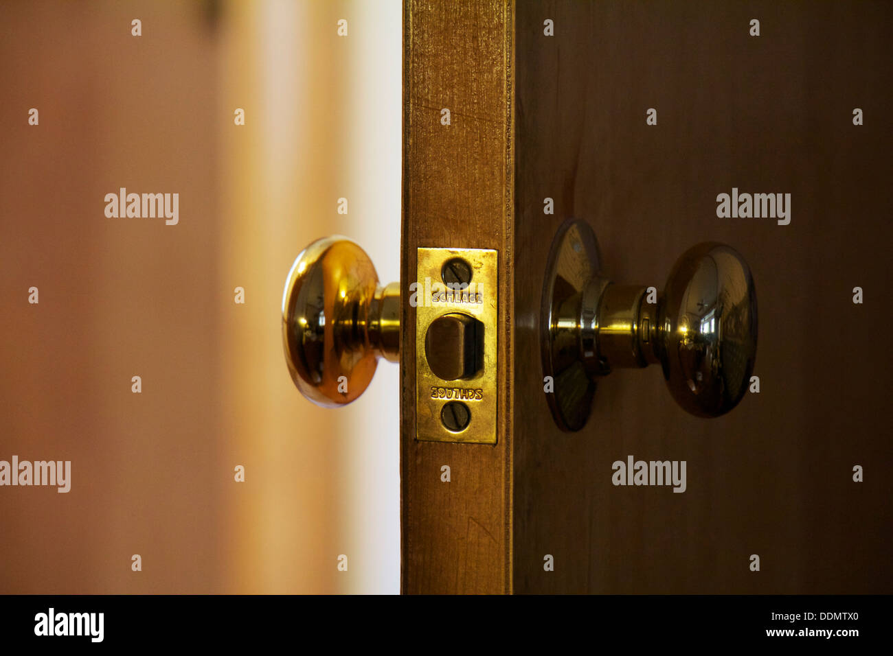 Open door, brass doorknobs and latch. Stock Photo