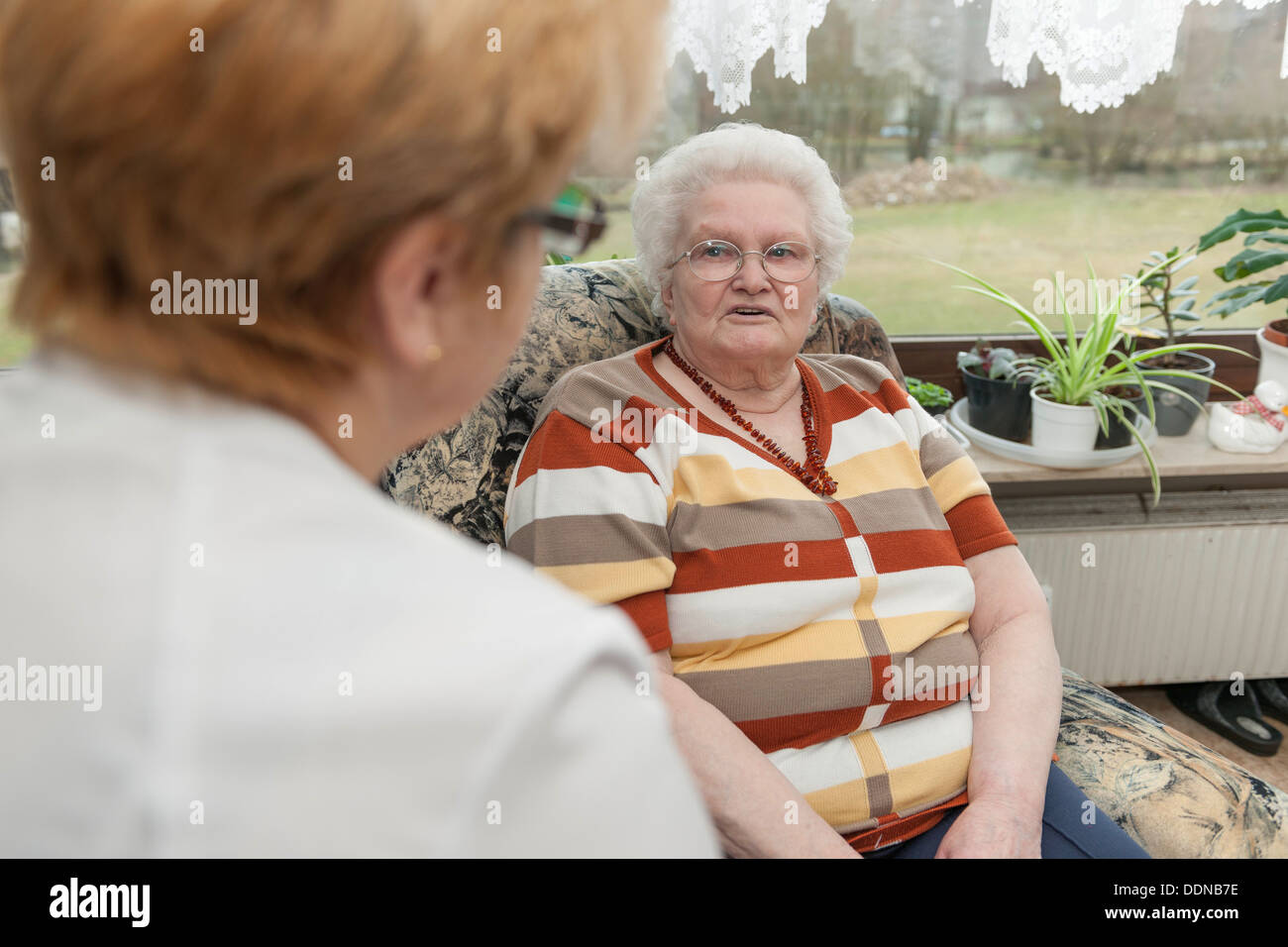 Geriatric nurse talking to old woman Stock Photo