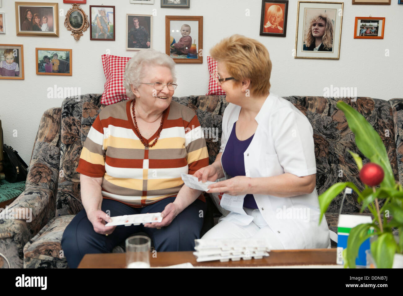 Geriatric nurse explaining medication to old woman Stock Photo