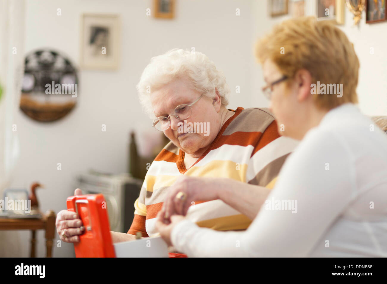 Old woman giving money to geriatric nurse Stock Photo