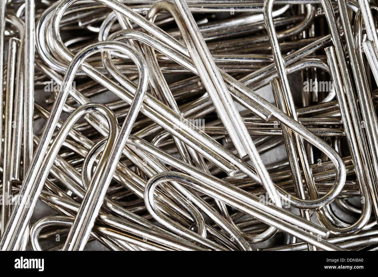 Scattered paper clips office equipment background. Stock Photo