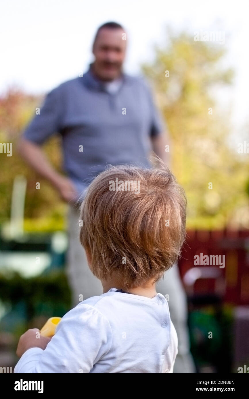 Toddler with father in garden Stock Photo