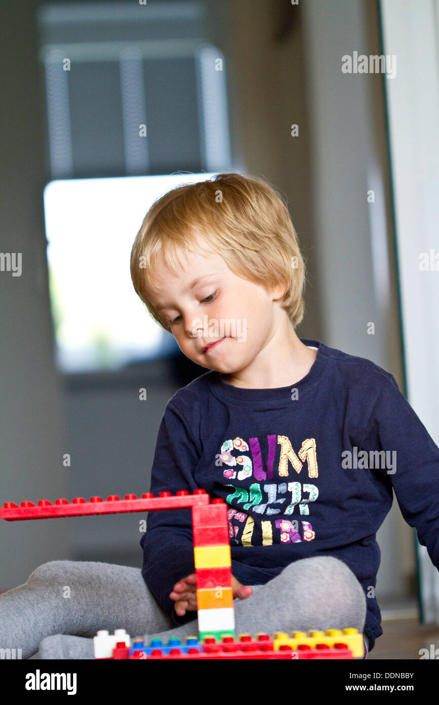 Blond girl playing with Lego Stock Photo