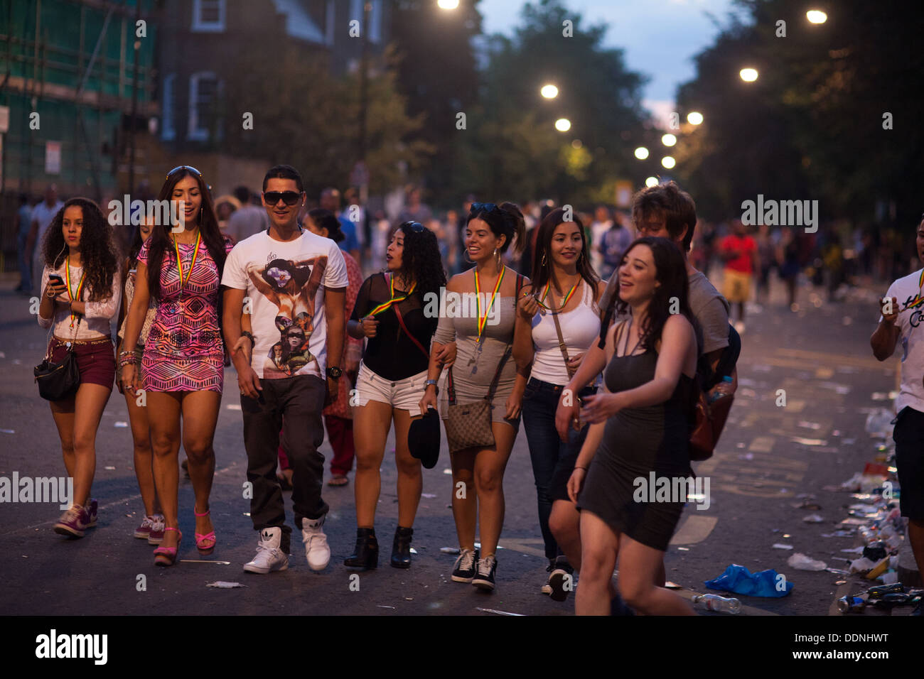 Happy party-goers heading home in the dying light on a summers evening in Notting Hill after the carnival. Stock Photo