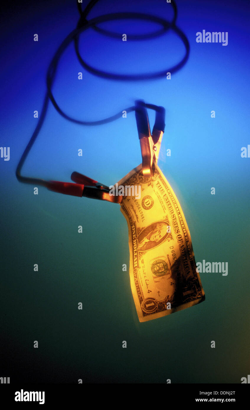 Jumper cables holding US Dollar bill Stock Photo Alamy