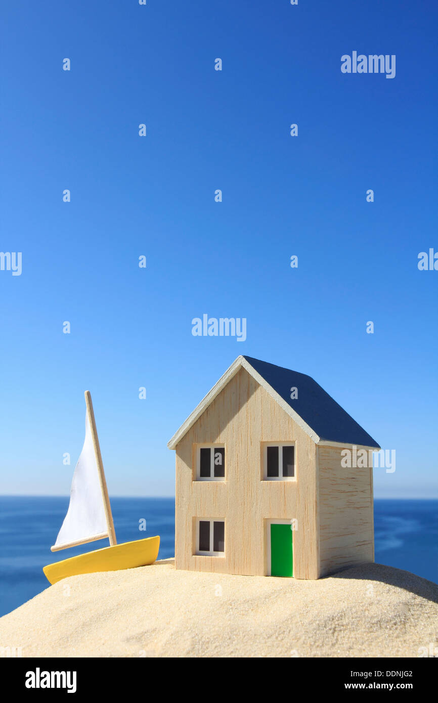 Model house and boat by the ocean Stock Photo