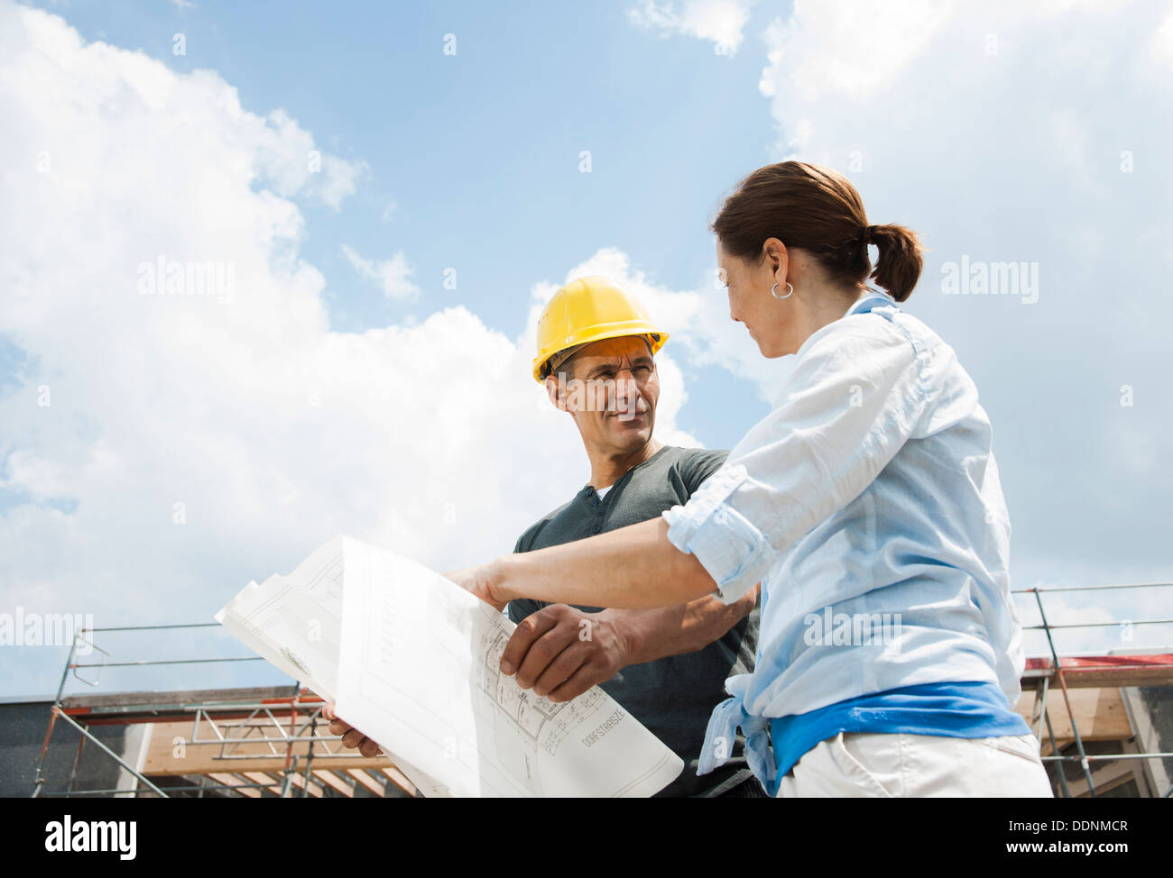 Foreman and client talking on construction site Stock Photo