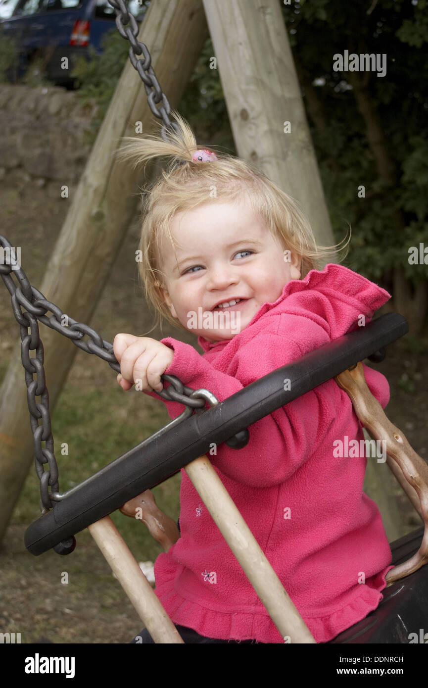 18 month old girl smiling on a swing Stock Photo Alamy