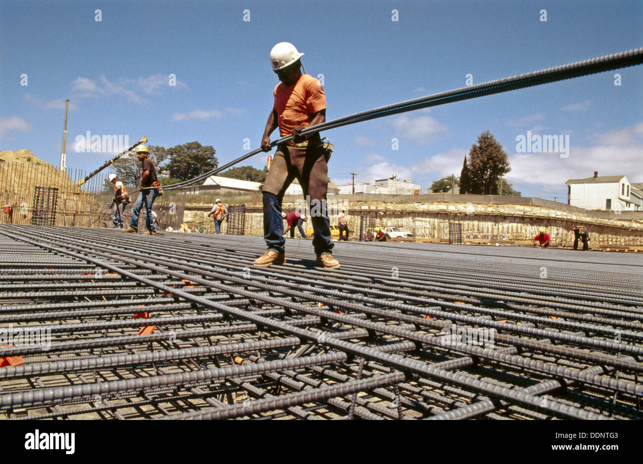 Ironworker carrying long rebar. I880 Cypress project. Oaklnad Stock