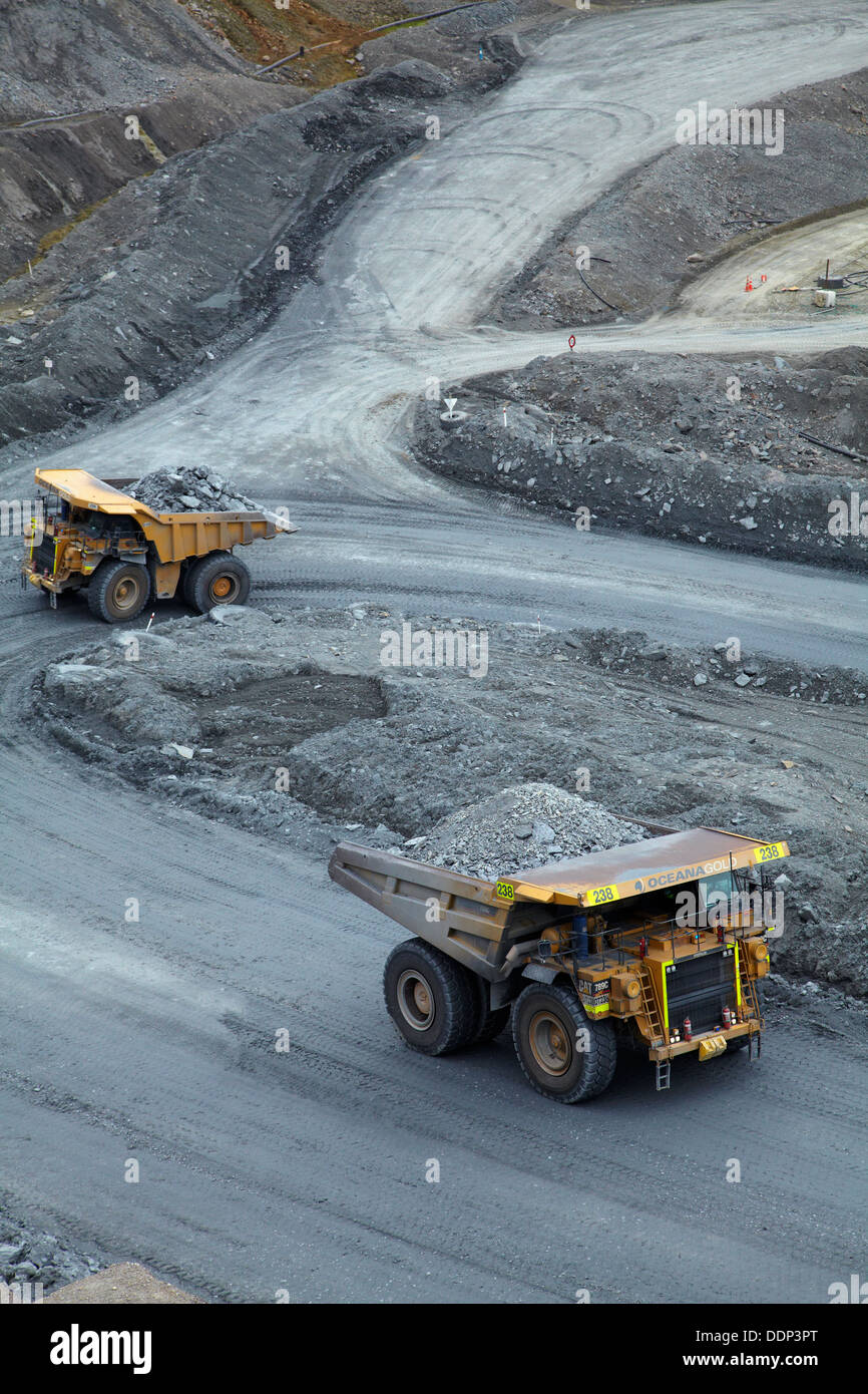 Giant dump trucks at Macraes open pit gold mine, Macraes Flat, near Palmerston, East Otago, South Island, New Zealand Stock Photo