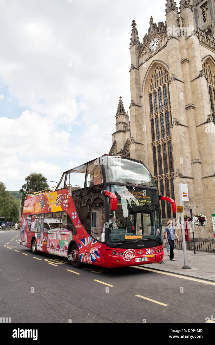 A red British, open top, double decker tourist sightseeing bus parked by the abbey in the center of Bath, Somerset, UK Stock Photo